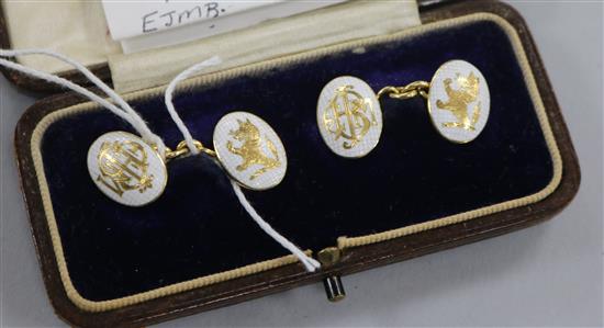 A pair of yellow metal and white enamel crested and monogrammed oval cufflinks, in box.